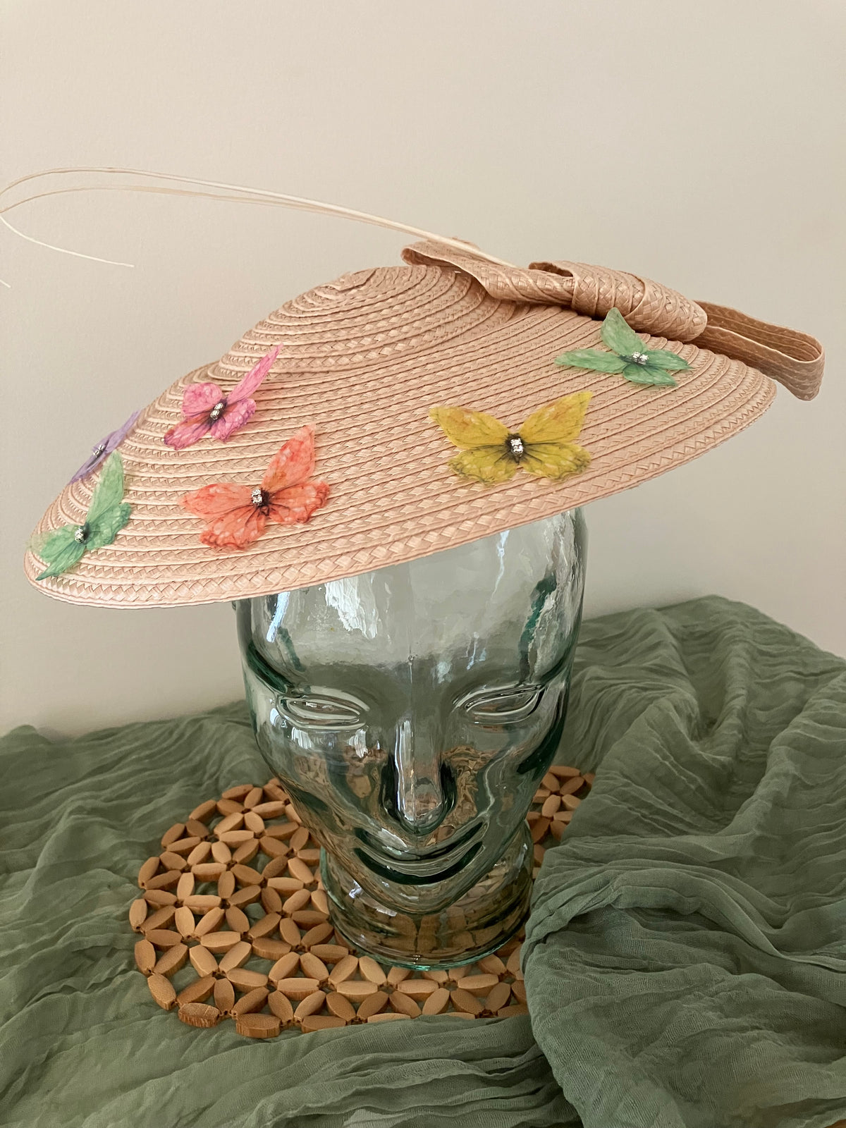 Ladies lightweight fascinator in a light peach-beige color with colorful fabric butterfies.