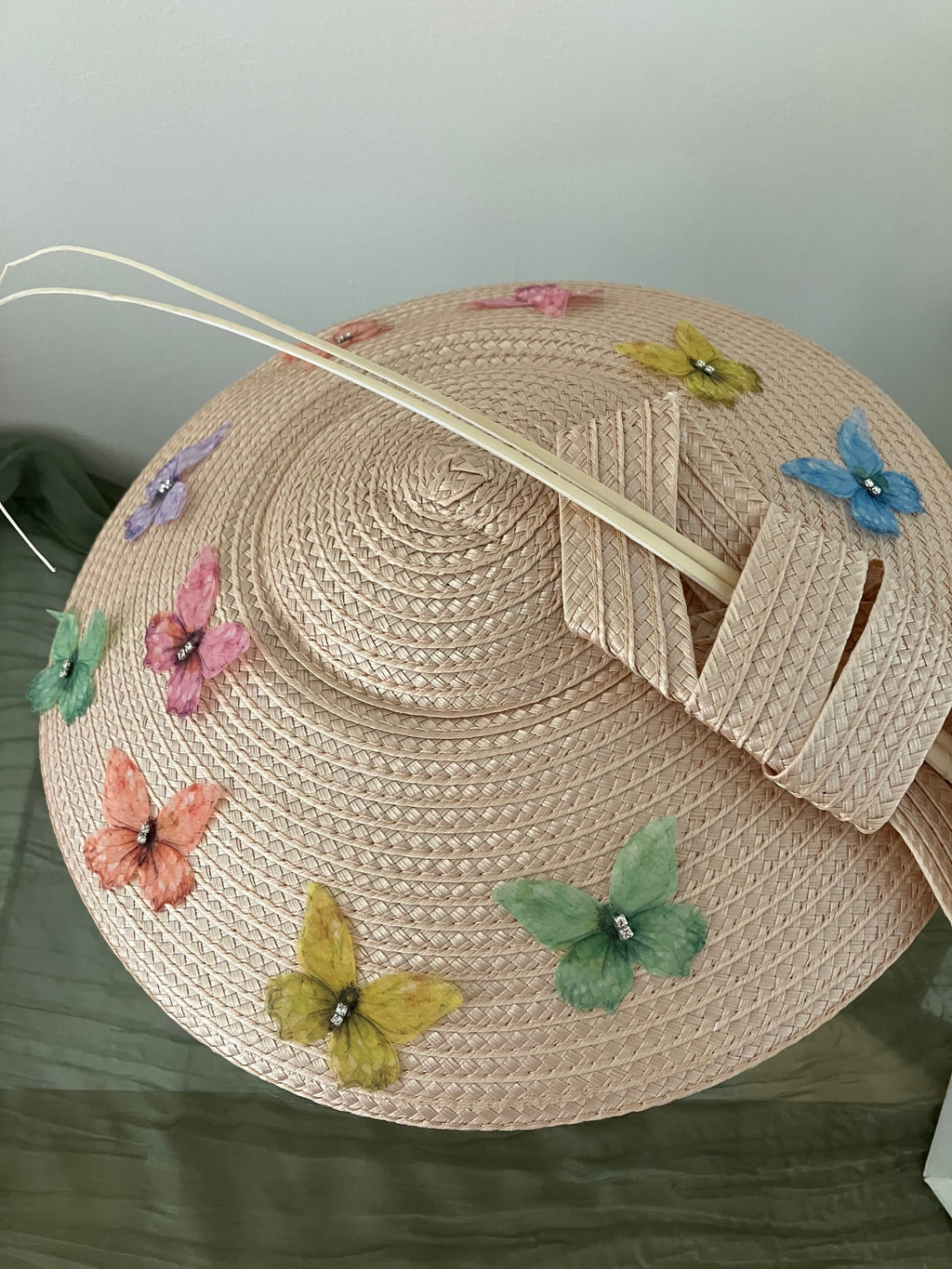 Ladies lightweight fascinator in a light peach-beige color with colorful fabric butterfies.