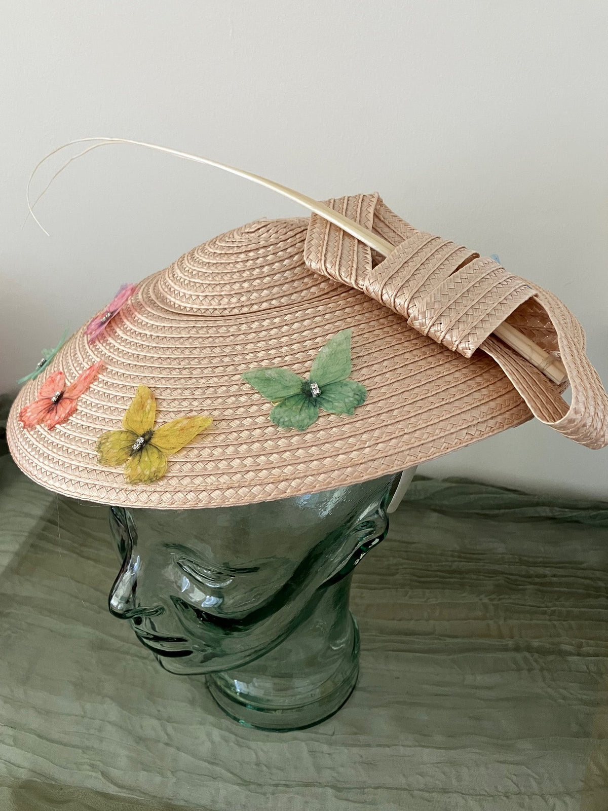 Ladies lightweight fascinator in a light peach-beige color with colorful fabric butterfies.