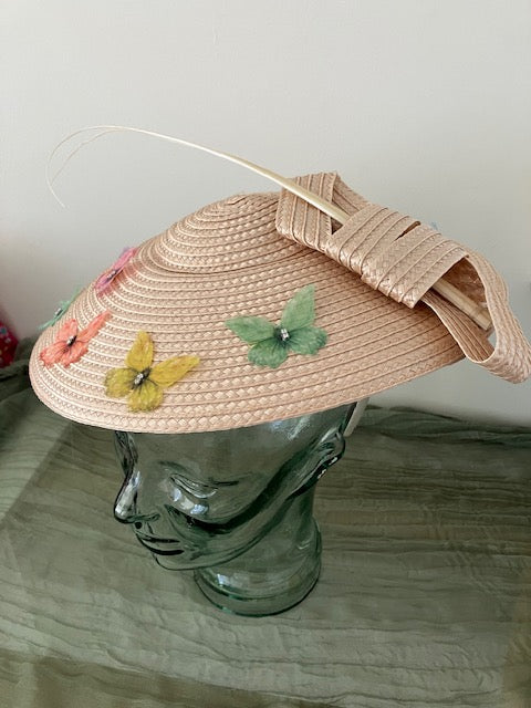Ladies lightweight fascinator in a light peach-beige color with colorful fabric butterfies.