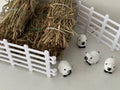 Small white sheep figurines with black faces.