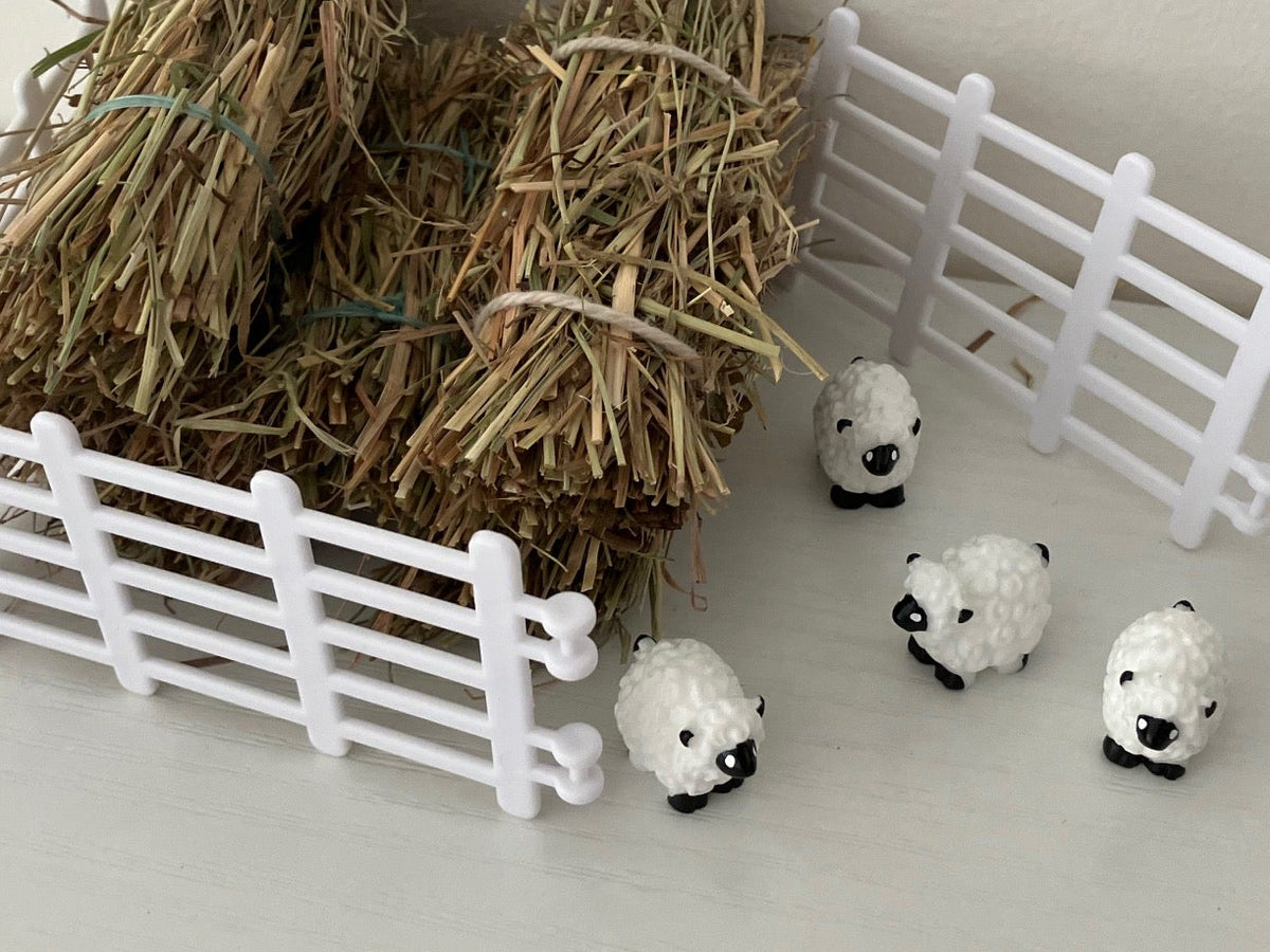 Small white sheep figurines with black faces.