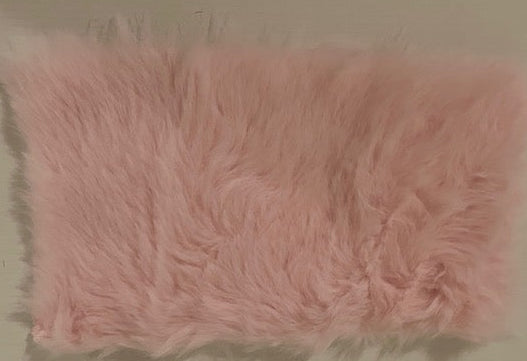 A rectangular pink faux fur cushion cover or pillow cover, shown flat against a neutral beige background.
