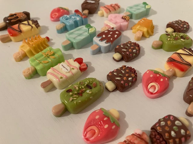 A collection of small, colorful novelty ice cream on a stick.