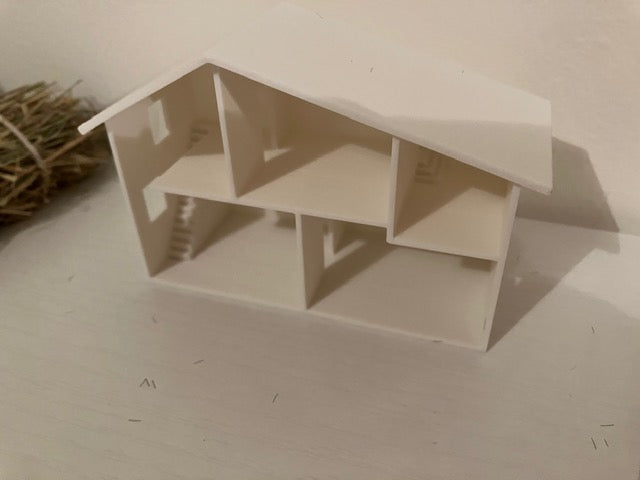 A small unfinished wooden house model with an open interior.