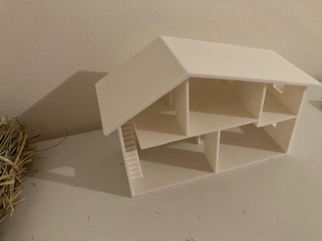 A small white plastic house-shaped organizer or storage box with multiple compartments.